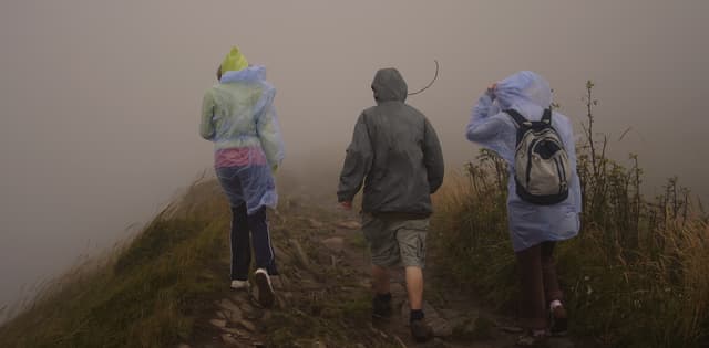 three people hiking in rainy weather