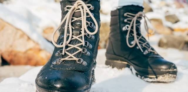 laced black winter boots in snow