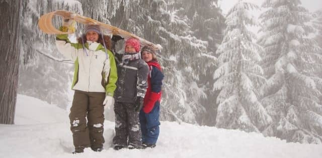 kids carrying a toboggan 