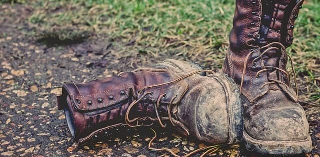 worn pair of work boots on the ground