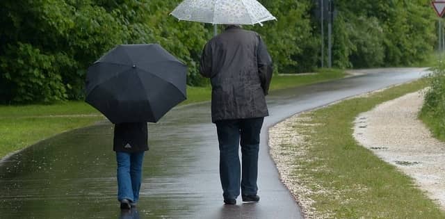 a couple walking in the rain with umbrellas