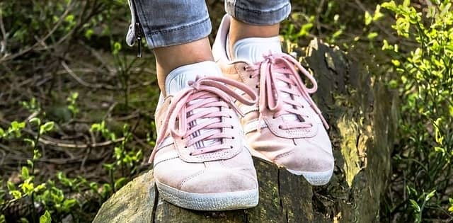 Girl standing on log wearing pink suede shoes